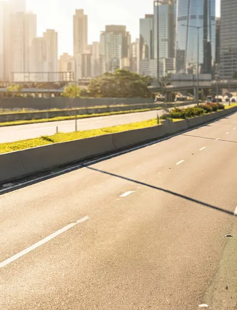 Una autopista urbana de firme liso con el moderno perfil urbano a la luz cálida del día